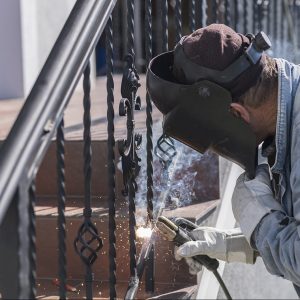 a,worker,welding,metal,handrails,on,the,stairs.,wrought,iron